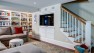 Light-Filled Basement Remodel – Den with Built-In TV and storage under stairs.