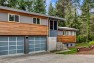 Split Level Exterior Makeover: The Modern Split – Board & Vellum – Glazed garage doors to upgrade the exterior of a 1970s home.