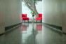 School of Visual Concepts – Red chairs at the end of a long hall.