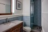 Seattle Box Remodel – Board & Vellum – Glass tile and walnut cabinets in the guest bathroom.