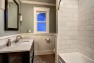 Seattle Box Remodel – Board & Vellum – Wainscot and large tile in the hall bathroom.