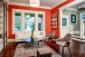 Seattle Box Remodel – Board & Vellum – Living room painted bright orange with white trim.