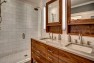 Seattle Box Remodel – Board & Vellum – Walnut cabinets in the master bathroom.