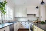 Kitchen Remodel with Classic Charm – Madrona Kitchen – Board & Vellum – Navy pendants over butter-colored cabinets.