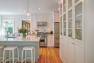 Bright white cabinets with glass doors in the kitchen. – Addition on Three Floors – Board & Vellum