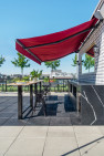 An extendable red awning over a rooftop bar.
