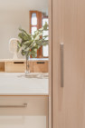 Soft-toned, custom wood cabinets in the Petite Condo Kitchen, by Board & Vellum.