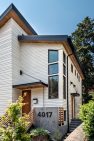 Steel channel awnings are suspended over the entry doors of this new home with a contemporary design.