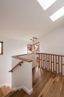 Midcentury modern railing details on a staircase with skylights above.