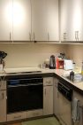 A view of a small ADU kitchen before a remodel to open up the kitchen to the living room.