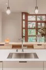 View from the kitchen sink over a bar counter to the living room beyond.