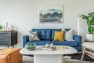 A blue couch in the living space of a model unit apartment in the Lucille on Roosevelt.