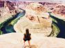 View of a hiker overlooking the dramatic river canyon at Horseshoe Bend.