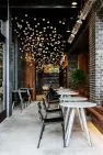 Café tables line the edge of an entryway passage to the lobby at the Lucille on Roosevelt. – Architecture, interior design, and landscape architecture by Board & Vellum.