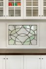 Close up view of salvaged antique leaded glass windows decorate the dining room of a remodeled Craftsman home.