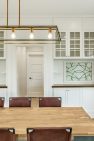 Salvaged antique leaded glass windows decorate the dining room of a remodeled Craftsman home.