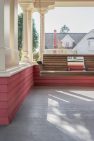 A classic porch swing on a large front porch on a Craftsman home.