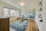 A baby's bedroom with blue decor and a mural of mountains.