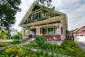 A classic Craftsman home painted red with white trim with a large front porch.