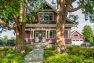 The view from the street of a classic Craftsman Manor painted red with white trim.