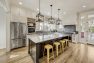 Yellow bar stools at a large kitchen island in a Craftsman home.