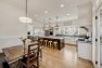 A breakfast nook tucked into the corner with a view of a large kitchen with island seating in a Craftsman home.