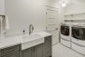 A laundry room tucked under the sloping roof of a Craftsman home.