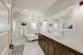 Master bathroom in a Craftsman home with double sinks and a clawfoot tub with a chandelier over it.