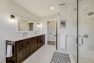 Master bathroom with double sinks and dark wood cabinets.