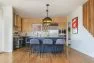 A remodeled kitchen with blue base cabinets and natural wood upper cabinets. – Board & Vellum, Custom Residential Design Services