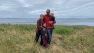 Lindsey, her husband, and children pose for a picture standing on a grassy bluff overlooking Puget Sound.
