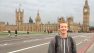 Tom stands on Westminster Bridge with Big Ben in the background.