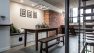 Looking into the dining area of The Urban Sanctuary. There's a small cat cut out in the bench seating at the table and a brick wall in the background.