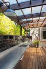 Translucent roofing panels allow daylight to keep this covered back deck bright. - Backyard Covered Kitchen – Board & Vellum