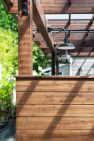 A covered wood deck with integrated lighting. - Backyard Covered Kitchen – Board & Vellum
