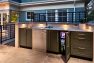 A fully-equipped outdoor kitchen. The mini-fridge is open showing cans of beverages.