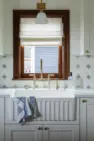 A bridge faucet and apron front sink add to the traditional charm of this light-filled kitchen. – Board & Vellum Interior Design