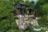 An architectural rendering of the exterior of a treehouse rental property. There is a large staircase connecting the exterior spaces to the interior of the property,