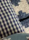 A vignette image of three textiles of varying texture in a blue and white color palette.