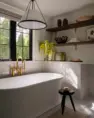 A bright primary bathroom with a free standing tub. Serene Modern Tudor — Board & Vellum