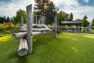 An image of a public park’s play structure made of heavy timber, with a covered picnic area beyond.