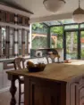 A view of this single-family home’s newly remodeled kitchen, featuring a solarium window wall, larger butcher block island, and pass through, built-in cabinet, along with smaller details, like a built-in paper towel drawer.