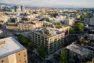 Aerial view of Tanager Apartments, two towers wrapping a planted central courtyard on a triangular Capitol Hill block. –Tanager Apartments – Board & Vellum