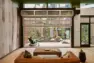 Resident amenity lounge at Tanager Apartments opening onto the courtyard through a large overhead door. – Tanager Apartments – Board & Vellum