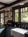 Runnels carved into the soapstone drain into farmhouse sink, under windows that look out to the backyard beyond. – Tangletown Craftsman – Interior Design for a Craftsman Home – Board & Vellum