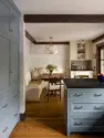View looking from the kitchen with its slate blue painted cabinets into the eating area where the banquette and coffee bar are painted a soft cream. - Tangletown Craftsman – Interior Design for a Craftsman Home – Board & Vellum