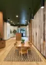 A large table surrounded by chairs on a rug in the amenity lounge area. – Tanager Apartments – Board & Vellum